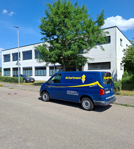 Firmenfahrzeug Dr. Hartmann vor Firmengebäude